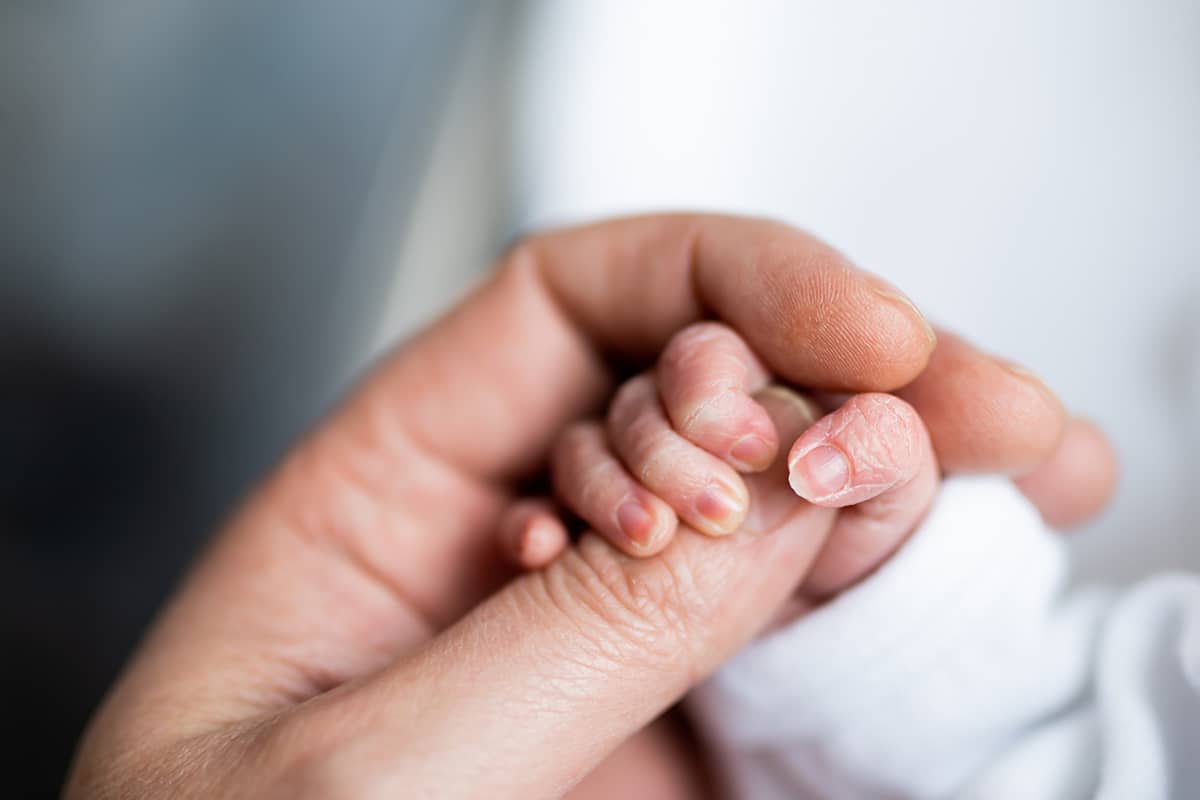 holding newborn hand