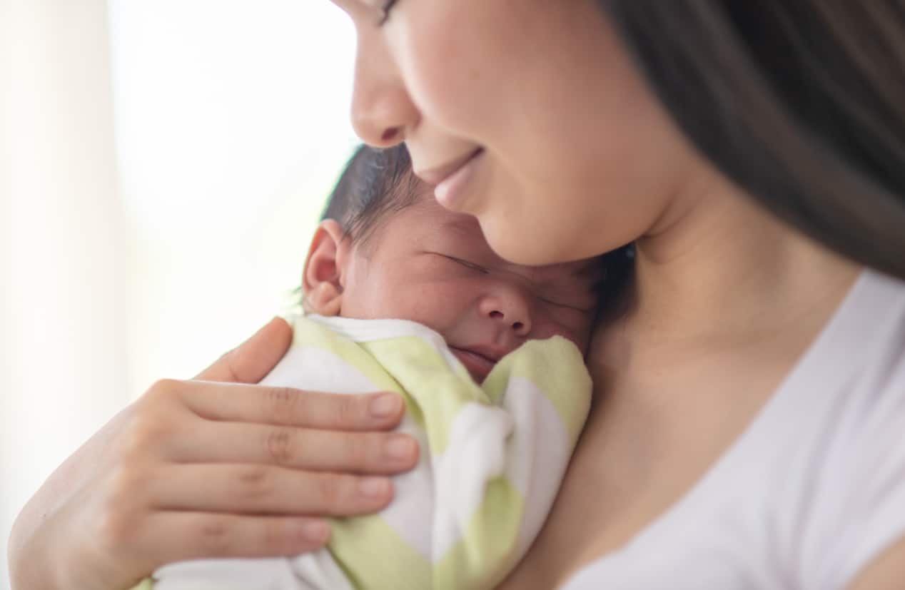 Mother snuggling newborn baby
